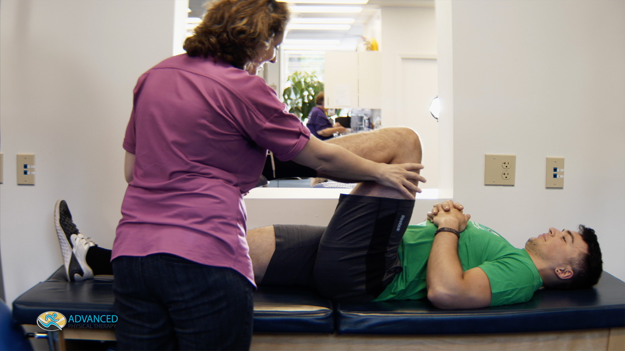 Man lying down doing physical therapy with nurse